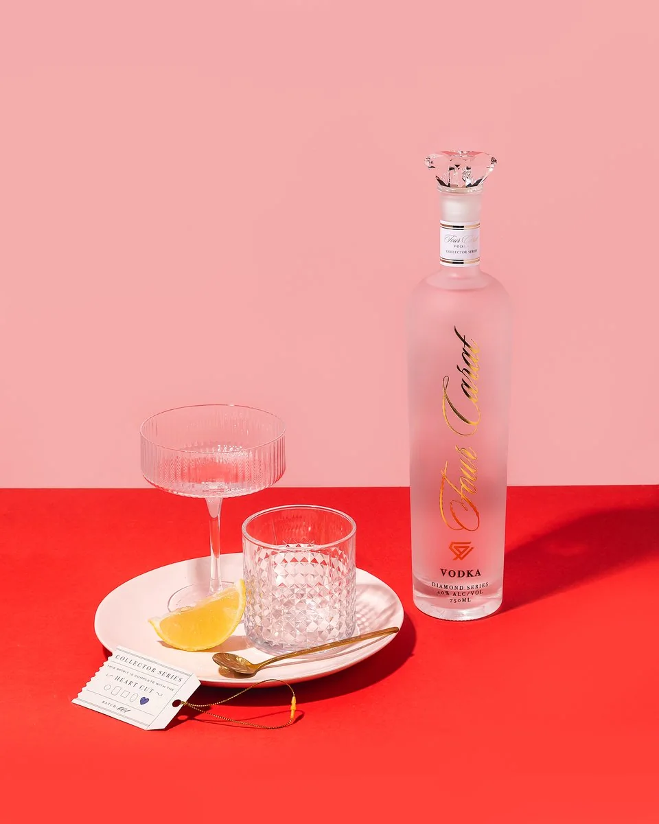 4 Carat pink bottle and cocktail styled on a vivid red surface